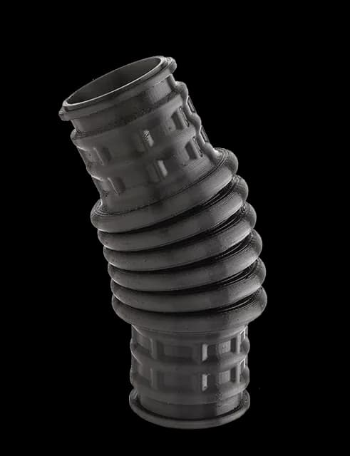 Black FDM TPU corrugated duct with printed ribbed cuffs, extrusion lines visible