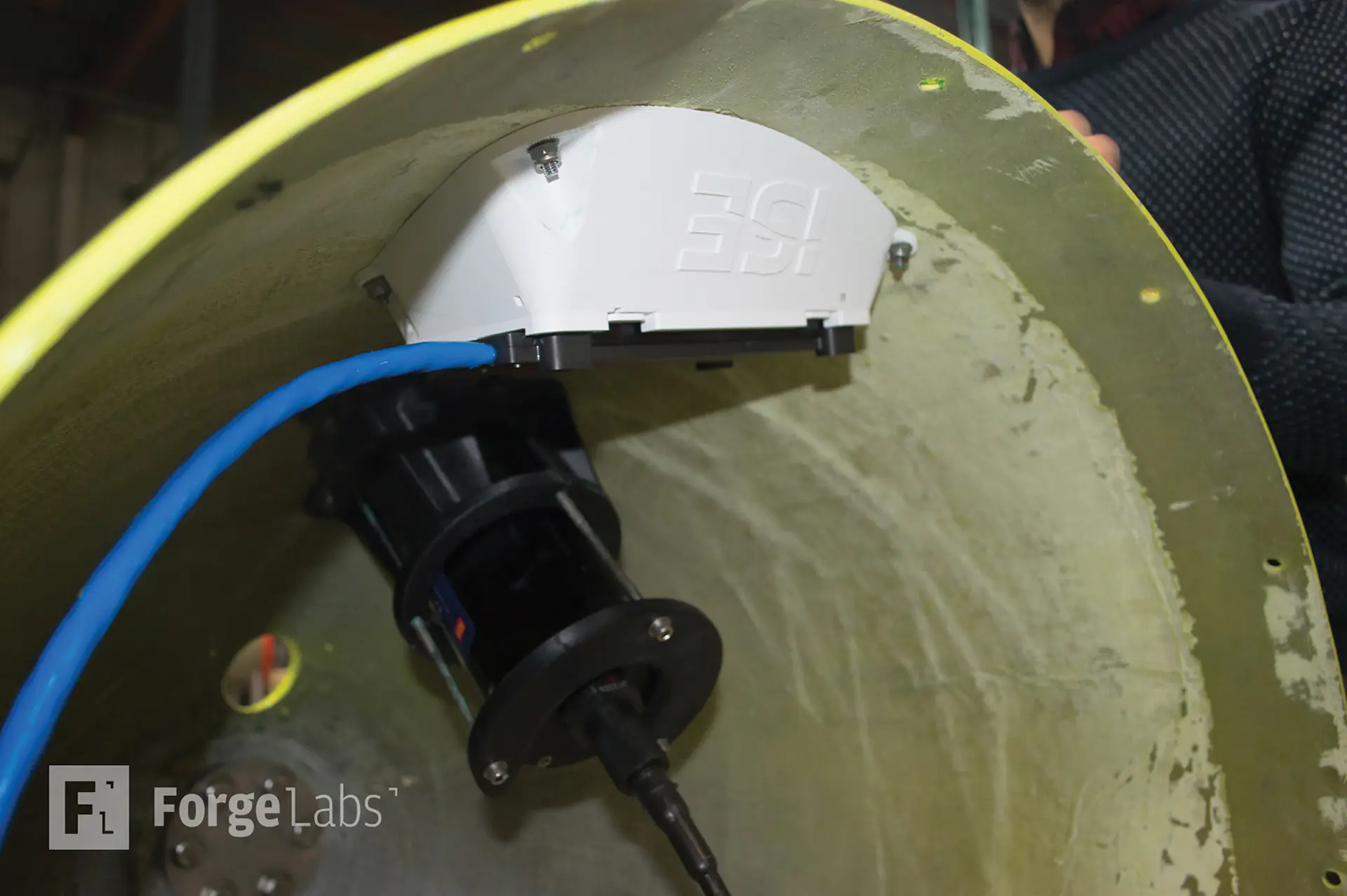 A white 3D printed ASA bracket with raised ISE lettering bolted inside a curved fibreglass hull section
