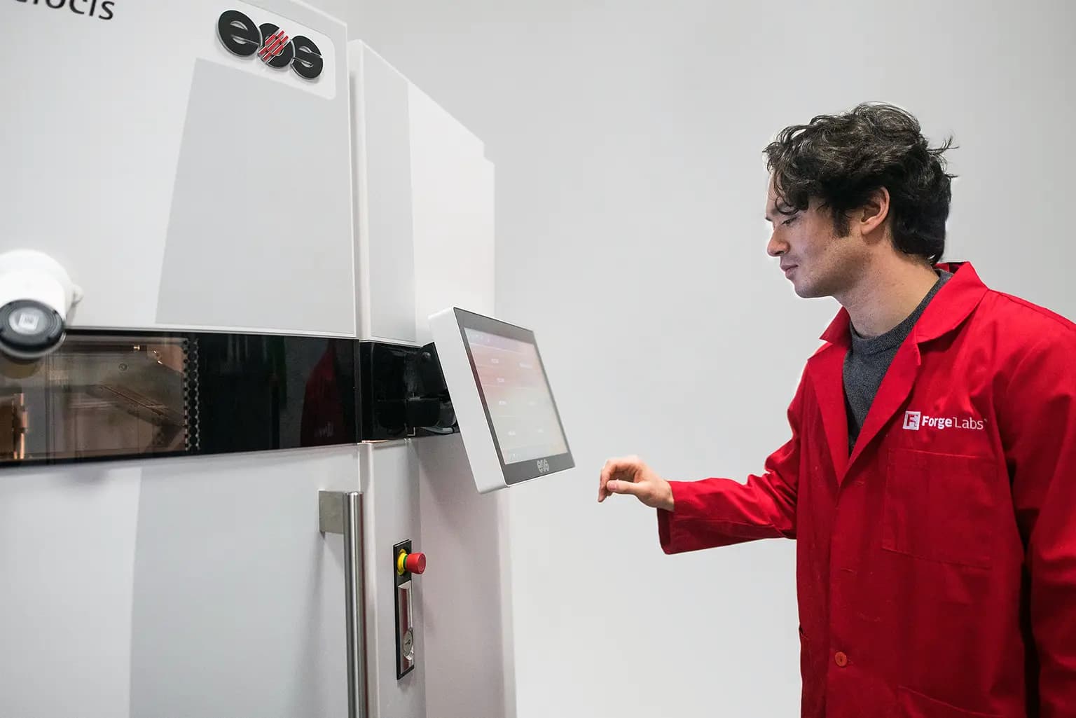 Forge Labs technician operating an EOS selective laser sintering printer