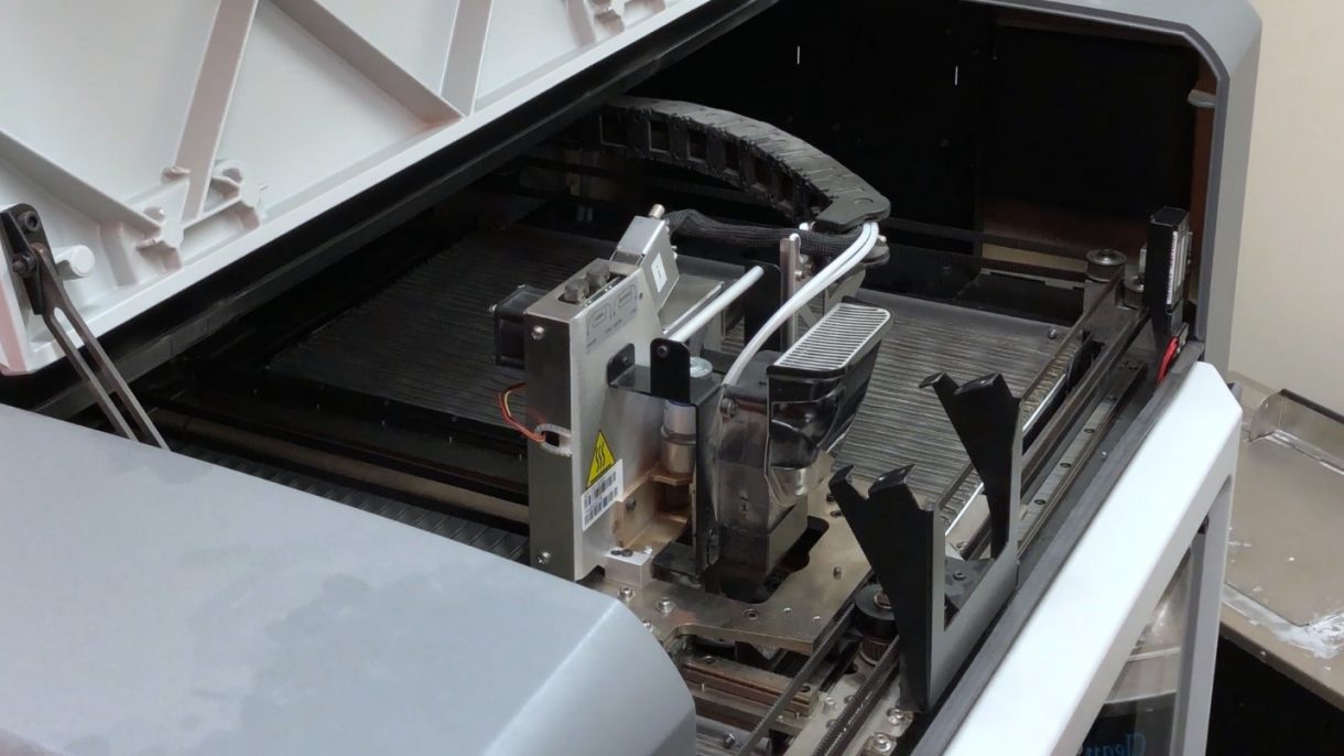 Close-up view of FDM print head showing precision nozzle and thermal control systems
